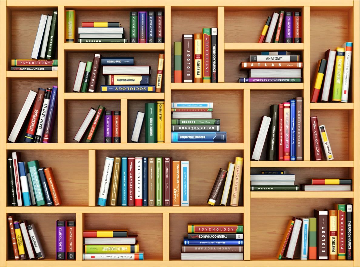 A wooden bookshelf filled with various books of different sizes and colors arranged vertically and horizontally in an organized manner.